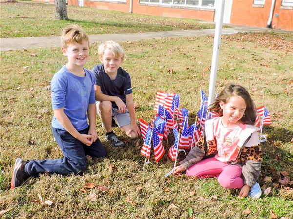 Students holding up homemade signs for a Veterans Day celebration.